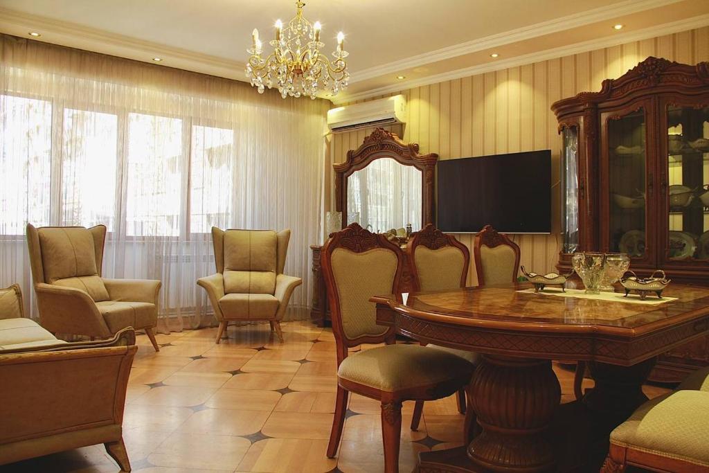 a dining room with a table and chairs and a chandelier at Rent House in Yerevan