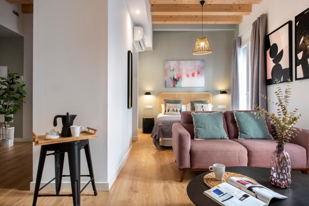 uma sala de estar com um sofá e uma cama em Lola 14 Suite Apartment em Sevilha