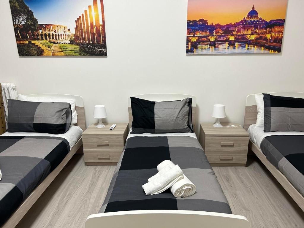 a bedroom with two beds and two paintings on the wall at Palmira's Rome Sweet Home in Rome