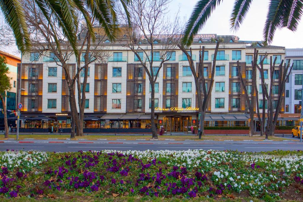 un grand bâtiment blanc avec des palmiers et des fleurs dans l'établissement Dosso Dossi Hotels & Spa Downtown, à Istanbul