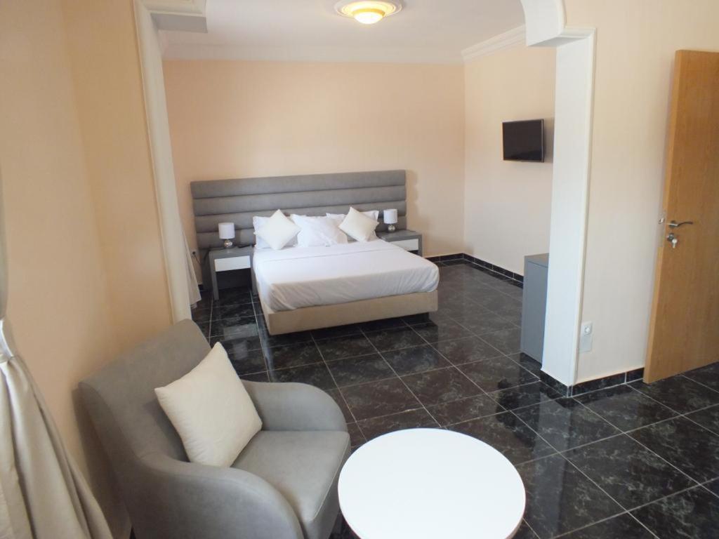 sypialnia z łóżkiem, krzesłem i stołem w obiekcie Hotel El Medina w Nawazibu