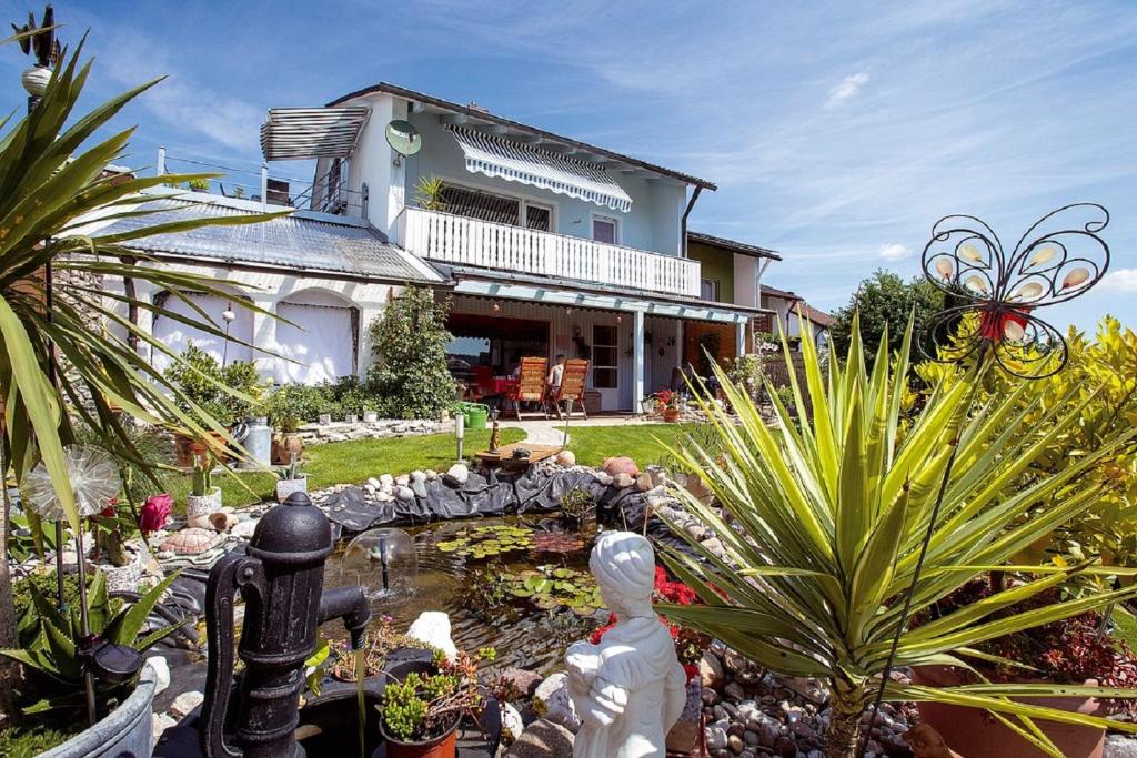 un jardín frente a una casa con un estanque en Pension Merbald, en Beilngries