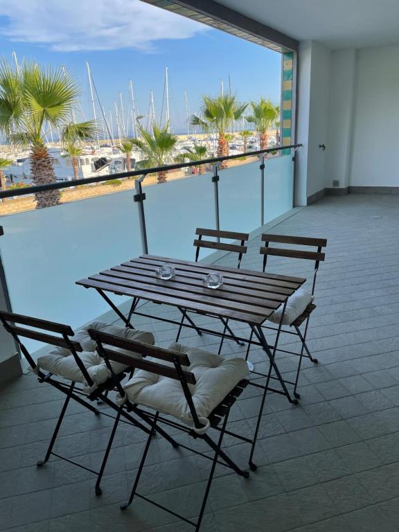 una mesa y sillas en un balcón con vistas al océano en San Lorenzo Marina Apartment, en San Lorenzo al Mare