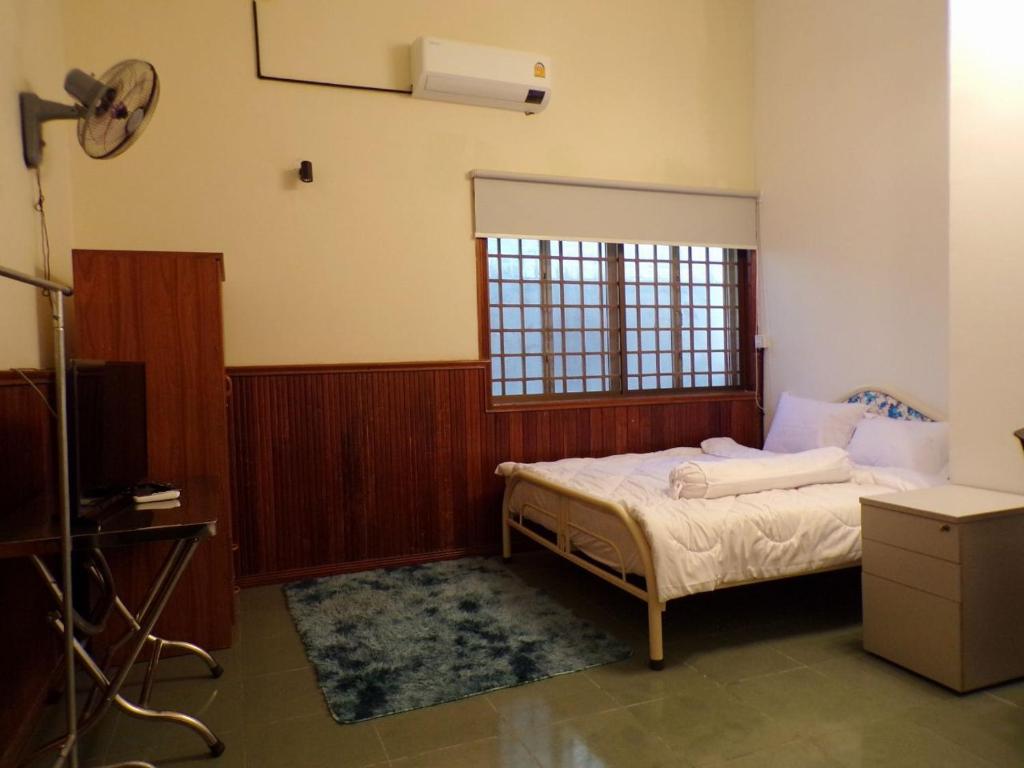 a bedroom with a bed and a tv and a window at Dimocrata in Phnom Penh