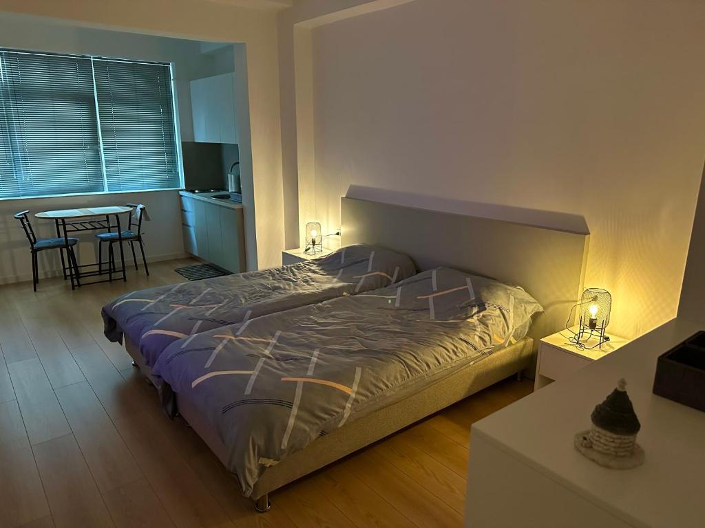 a bedroom with a large bed and a table with chairs at Studio apartment in amazing location! 24h check-in in Tirana