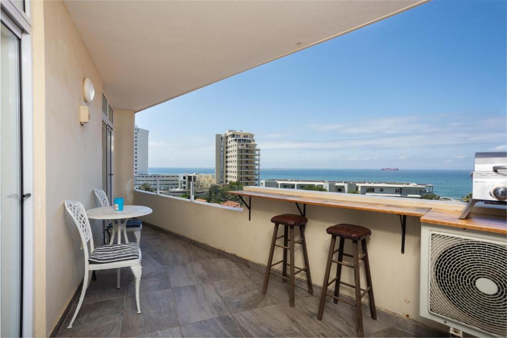 a balcony with a table and chairs and a view of the ocean at 24 Sea Lodge - Sea Viewing Apartment in Durban