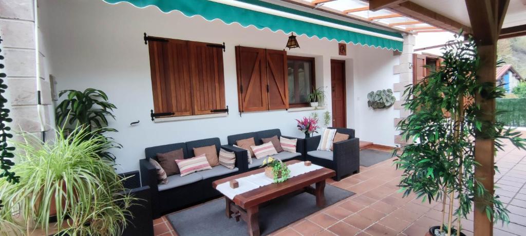 eine Terrasse mit Sofas, einem Tisch und Pflanzen in der Unterkunft Turismo Rural La Tablá in Alles