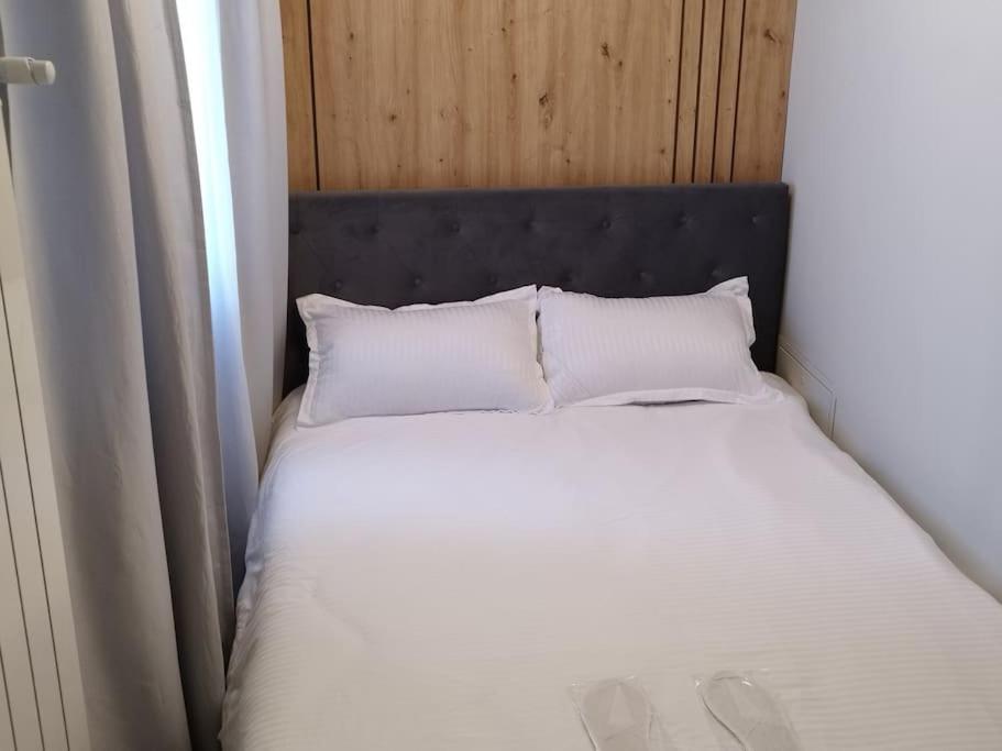 a bed with a black headboard and two white pillows at A G Studio's Palas-Iasi in Iaşi