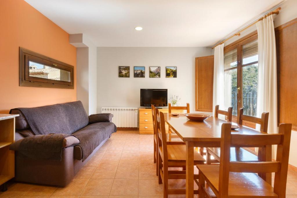una sala de estar con un sofá y una mesa en Apartamentos Casa Aurelia, en Alquézar