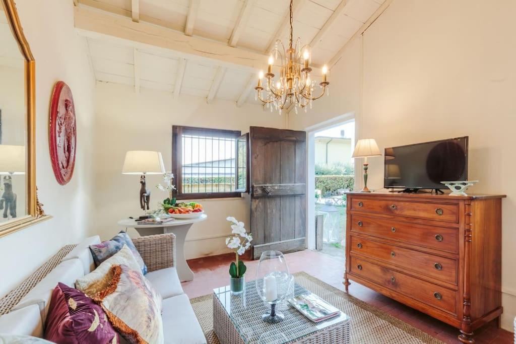 - un salon avec un canapé, une télévision et une commode dans l'établissement Villa Cesare 4 bedroom Villa with Pool, à Lucques