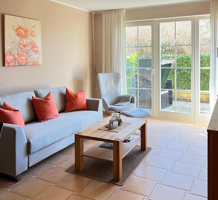 a living room with a blue couch and a coffee table at Villa Böck am Strand FeWo 8 in Glowe