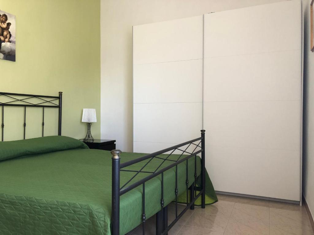 シャッカにあるAppartamento Maranto via Slovenia 12のベッドルーム(緑のベッド1台、クローゼット付)