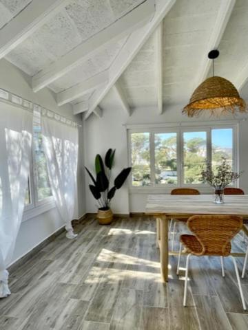 a room with a table and chairs and windows at BINIFORCAT in Cala en Forcat