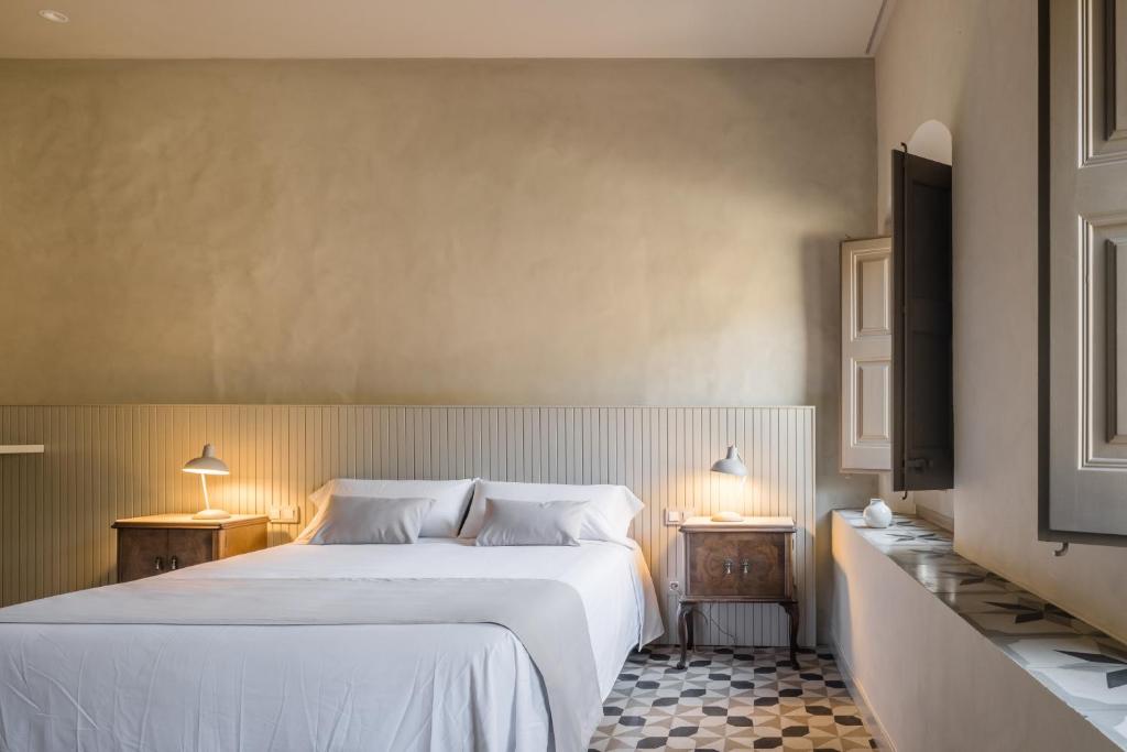 a bedroom with a large white bed and two lamps at Casa Fàbregas - Benestar Natural in Viladrau