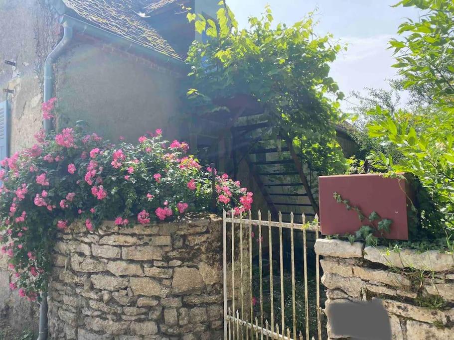 a garden with flowers on a stone fence at Chez Trudi Charmante maison à la campagne in Livry