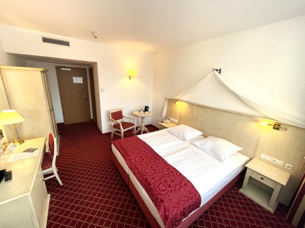 um quarto com uma cama grande num quarto de hotel em Hotel Chateau Kurfürstendamm em Berlim