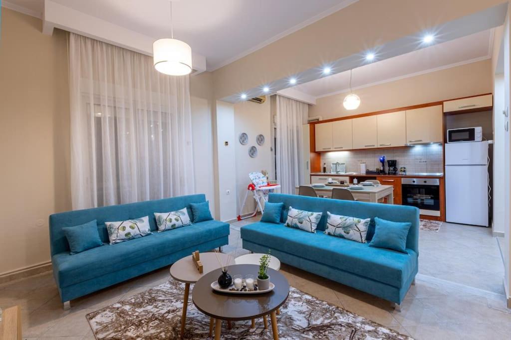 uma sala de estar com um sofá azul e uma mesa em Anna's House em Komotini