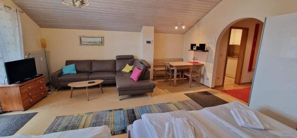 ein Wohnzimmer mit einem Sofa und einem Tisch in der Unterkunft ciao-aschau FeWo Schöne-Aussicht in Aschau