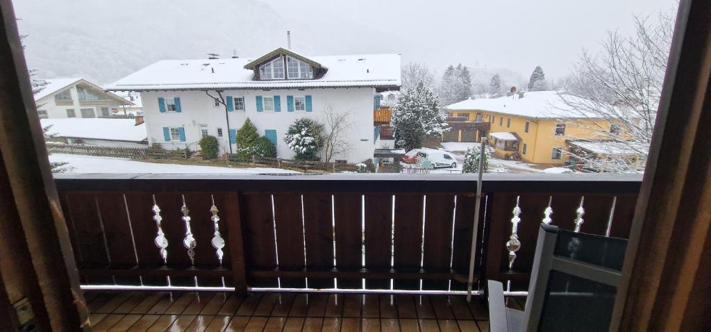 d'un balcon avec vue sur une cour enneigée. dans l'établissement ciao-aschau FeWo Schöne-Aussicht, à Aschau