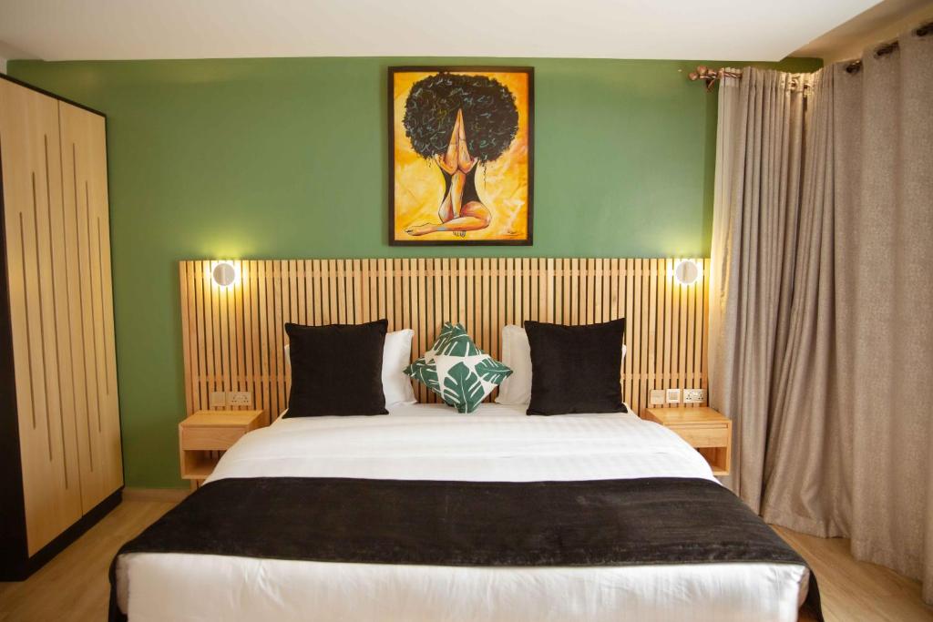 a bedroom with a large bed with a green wall at Saphir Boutique Hotel in Kigali