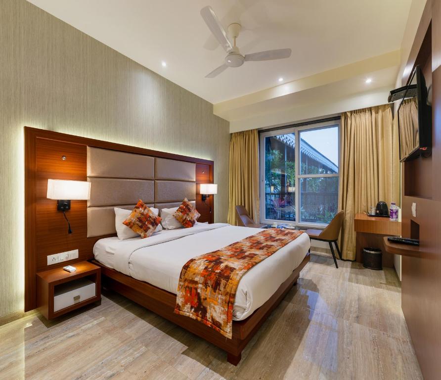 - une chambre avec un grand lit et une grande fenêtre dans l'établissement Hotel Town Palace-Best Business Hotel in Bijapur, à Bijapur