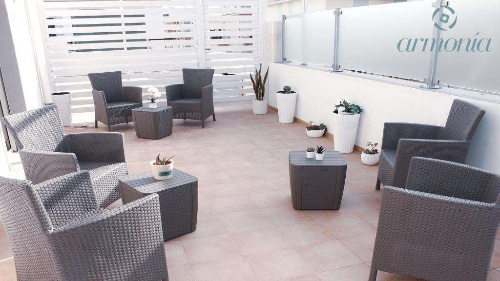 una sala de espera con sillas, mesas y plantas en B&B Armonia Vieste, en Vieste
