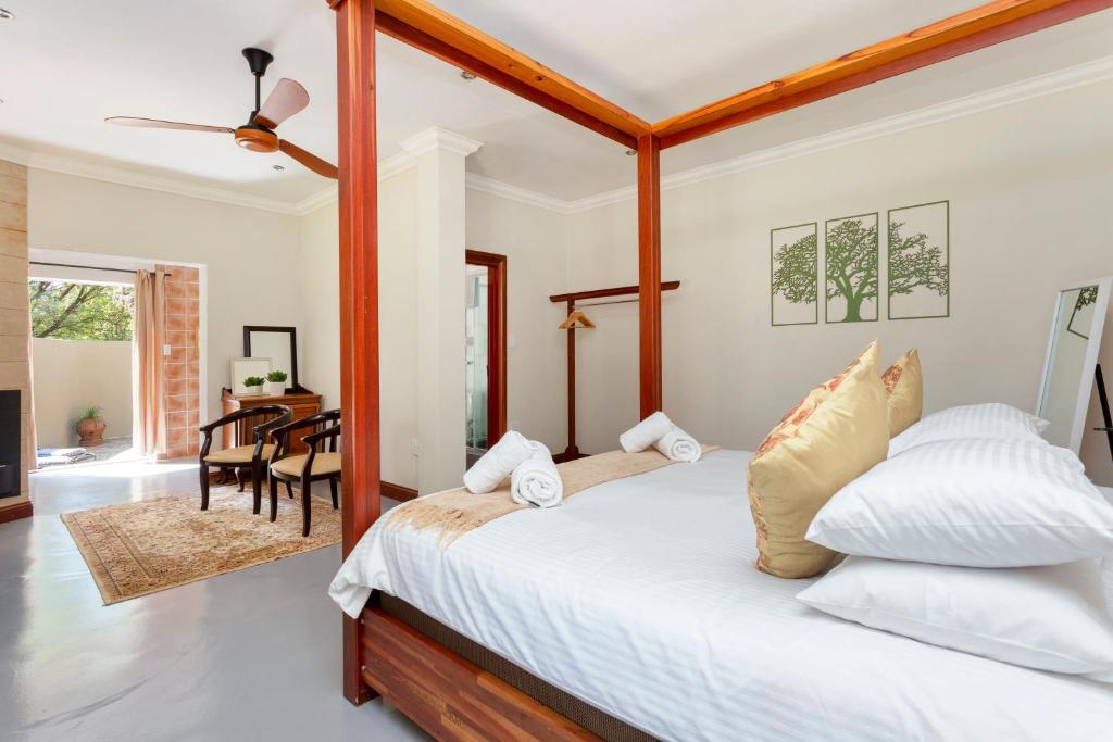 een slaapkamer met een bed en een eetkamer bij Teak Place Guest Rooms in Krugersdorp