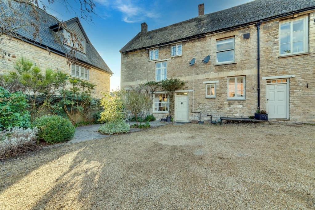 a large brick house with a gravel driveway at Music School Cottage 1 in Oundle
