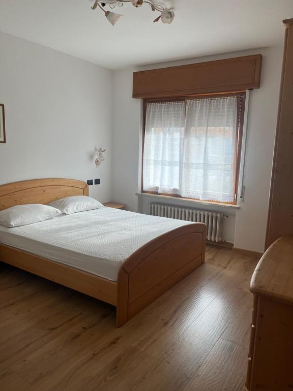 a bedroom with a large bed and a window at Casa Berlanda in Fiera di Primiero