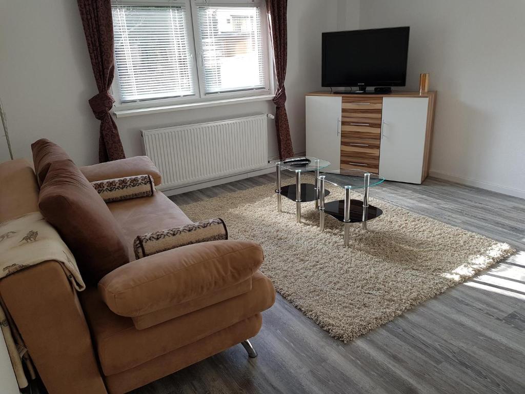 uma sala de estar com um sofá e uma televisão em NEU! Ferienwohnung Yuva Bad Harzburg em Bad Harzburg