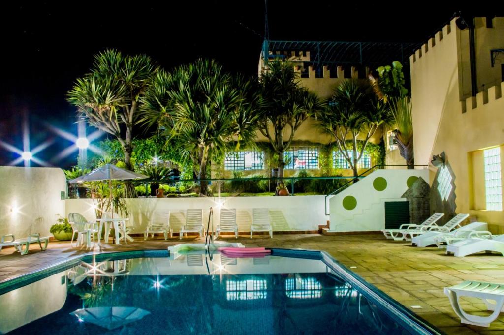 a swimming pool in a resort at night at SR Boutique Hotel in São Pedro