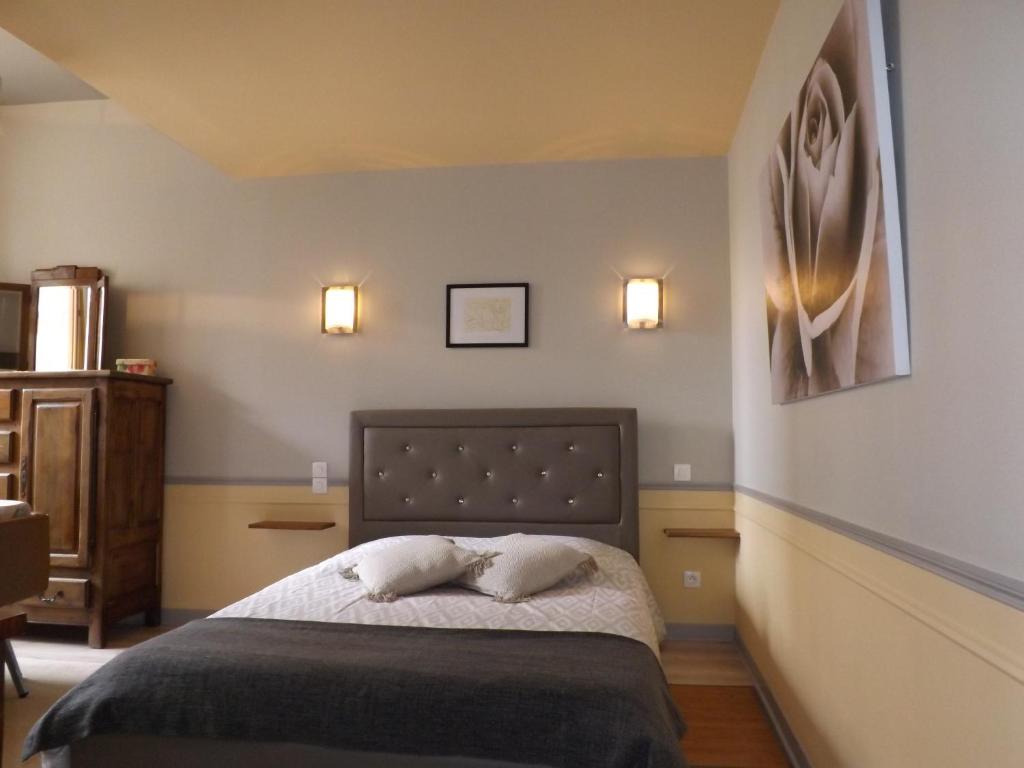 a bedroom with a bed with two pillows on it at HOTEL particulier LARIBOISIERE in Fougères