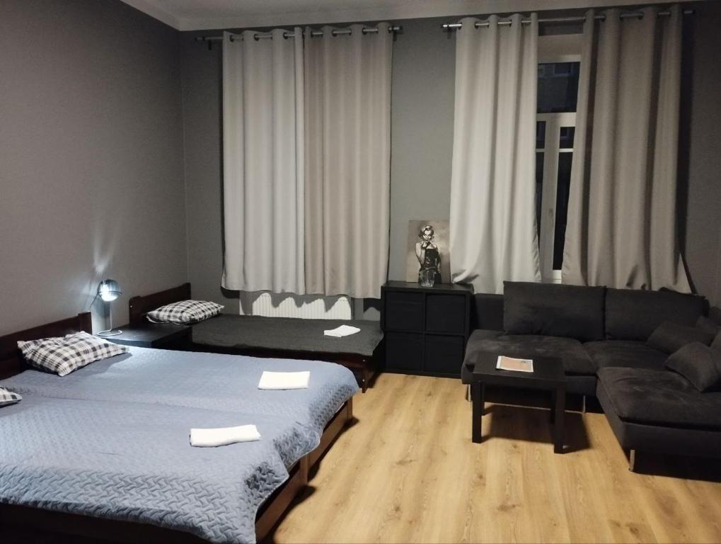 Centro Hostel في فيلنيوس: غرفة معيشة بها سريرين وأريكة