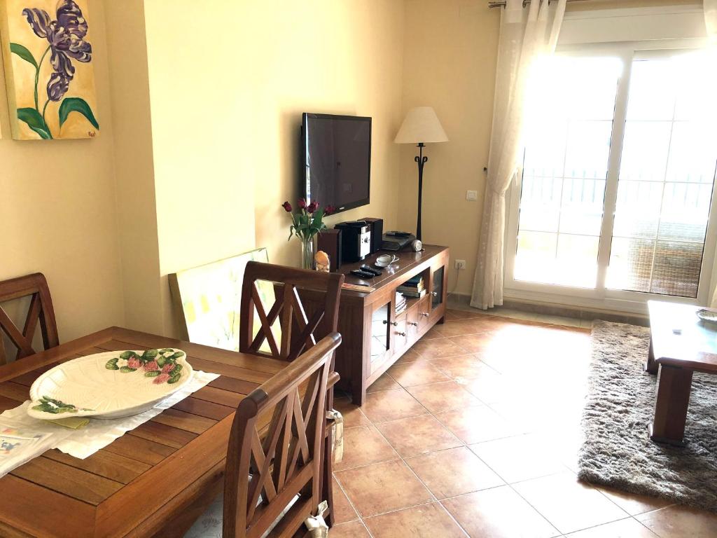 a dining room with a table and a television at Marina Isla Canela apartment in Huelva