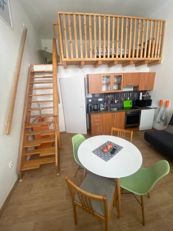 a living room with a table and chairs and a staircase at Apartmán v Lesní in Jablonec nad Nisou