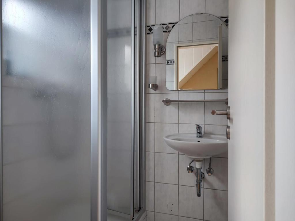 a bathroom with a sink and a mirror and a shower at Gästehaus im Alten Fährhaus in Cochem