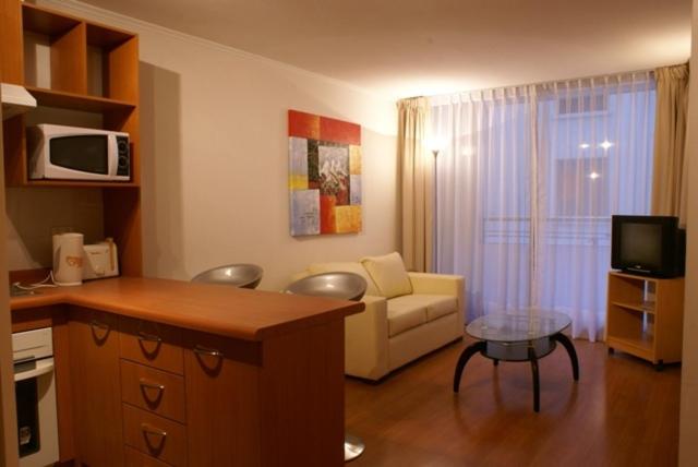 a living room with a couch and a microwave at Apart Hotel Agustinas Plaza in Santiago