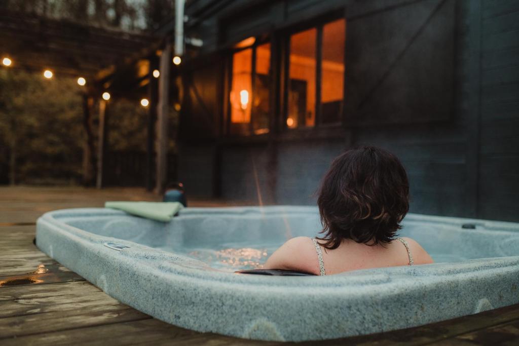 a woman sitting in a jacuzzi tub at Ô NaNo Glamping in Dalhem