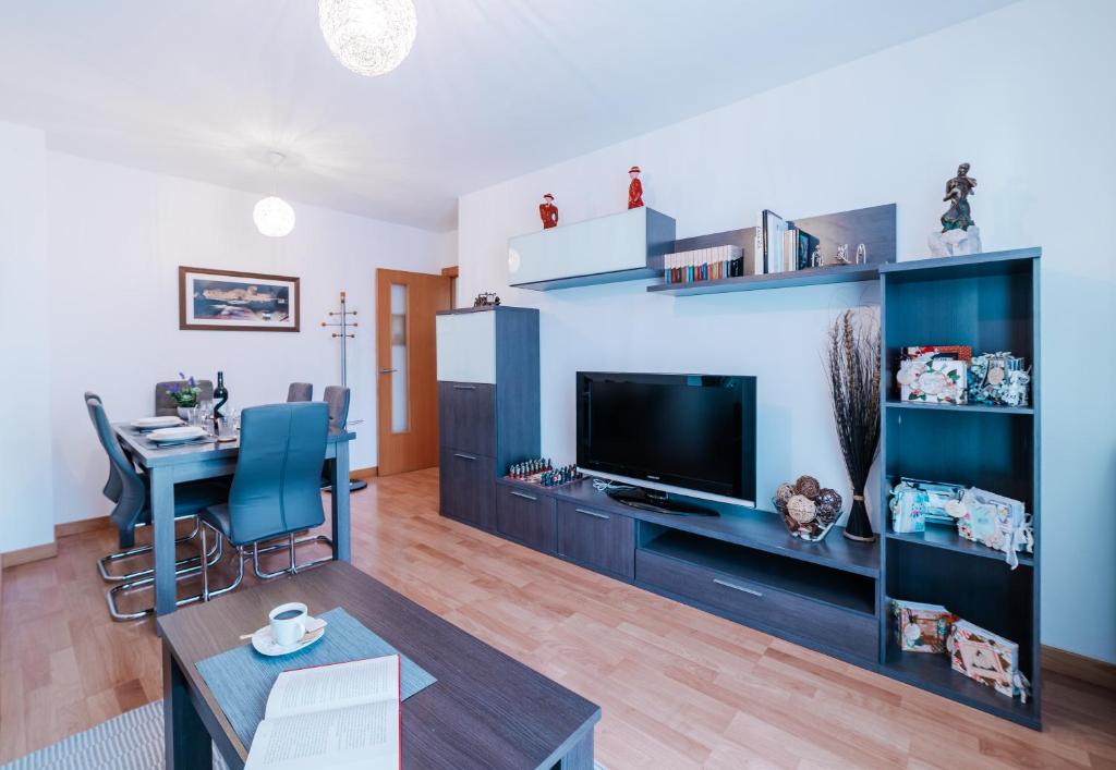 sala de estar con TV y mesa de comedor en La Tarasca Apartamento turístico en Zamora