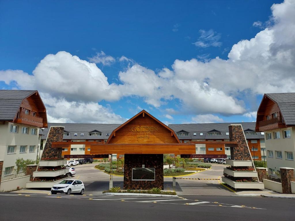 Golden Gramado Resort في غرامادو: مبنى فيه سيارة متوقفة في موقف للسيارات