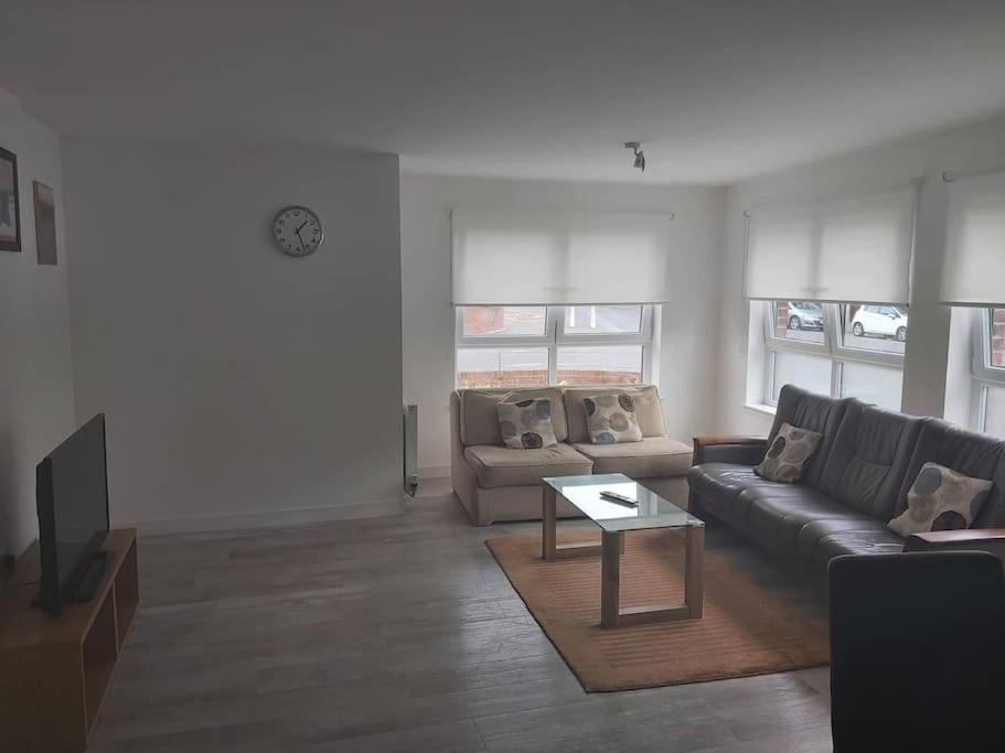 uma sala de estar com um sofá e uma mesa em City, Celtic park & Emirates Stadium Apartment, for families or age over 23 em Glasgow