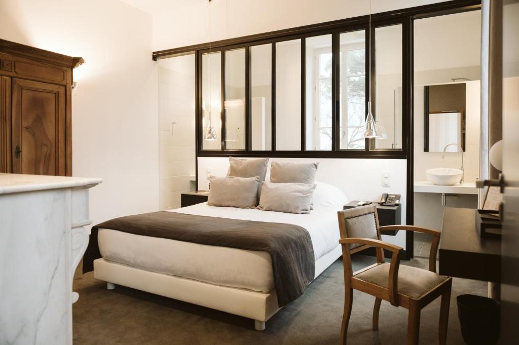 een slaapkamer met een bed, een bureau en een stoel bij Domaine d'En Fargou in Saint-Sulpice