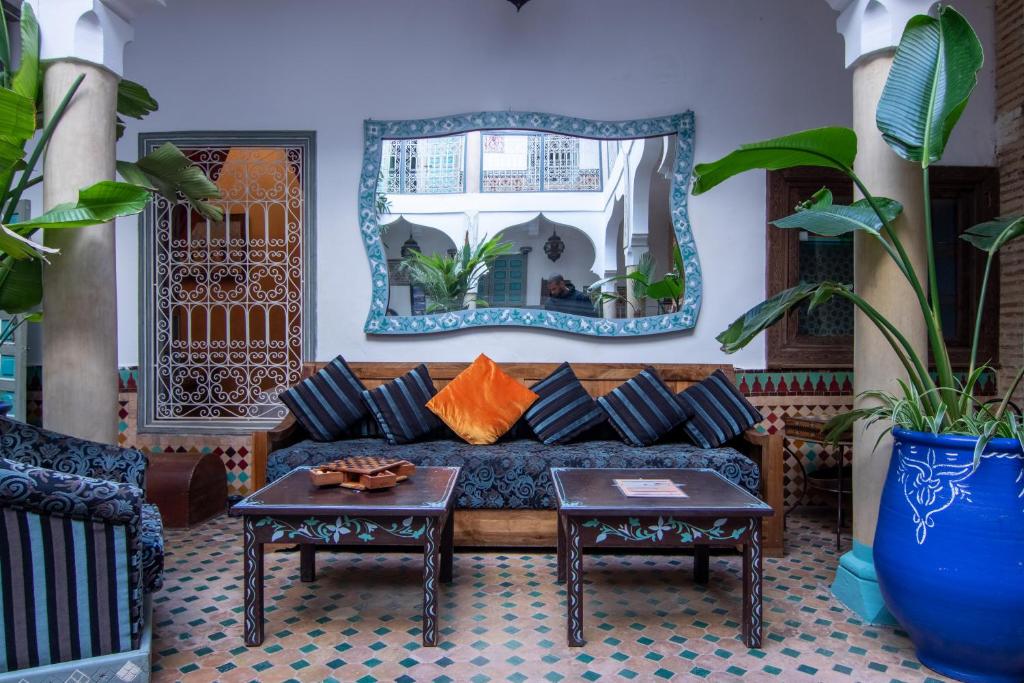 een woonkamer met een bank en een spiegel bij Riad Zinoun & Spa 9 Rooms in Marrakesh