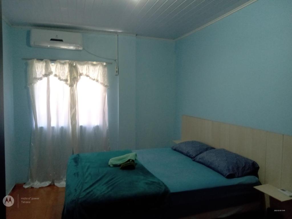 um quarto com uma cama e uma janela com uma almofada em Apart Hotel Esperança em Ametista do Sul