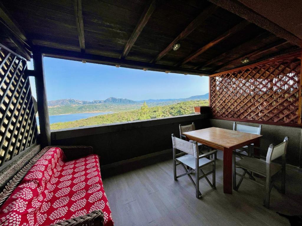 Una habitación con una mesa y sillas y una ventana grande. en Casa Raffa by Wonderful Italy, en Porto Rotondo