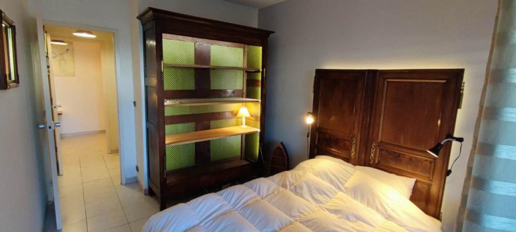 ラ・ロシェルにあるAu Jardinのベッドルーム1室(ベッド1台、木製ヘッドボード付)