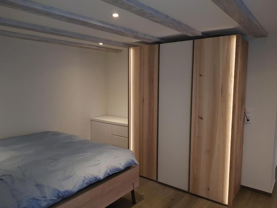 Un dormitorio con cama y armario. en 47 qm- Suite mit grosszügiger Terrasse, en Oberterzen