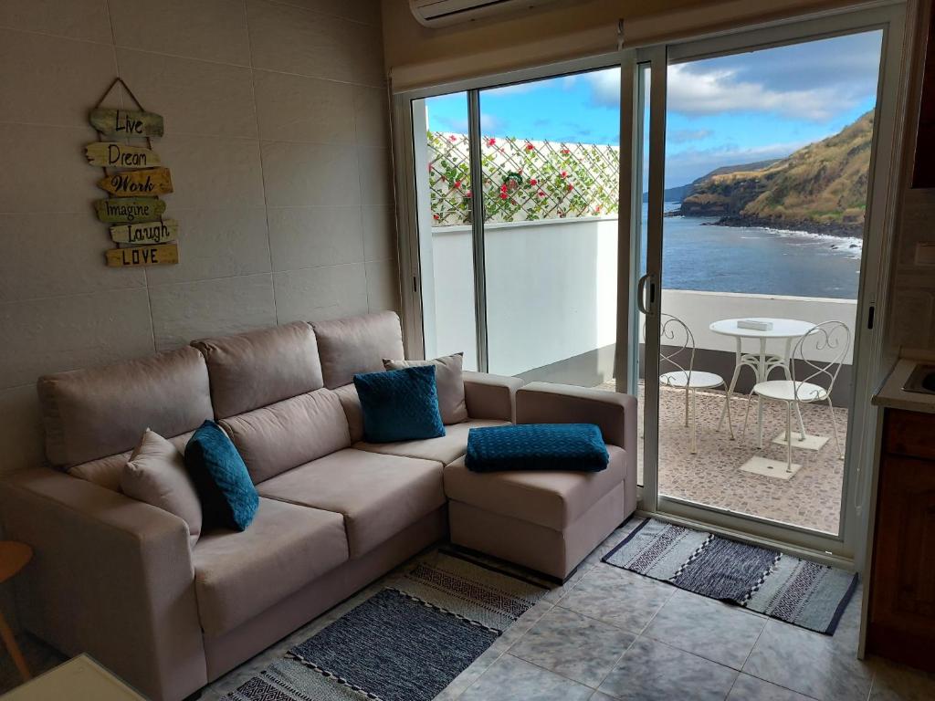 a living room with a couch and a view of the ocean at Mar de Prata in Maia
