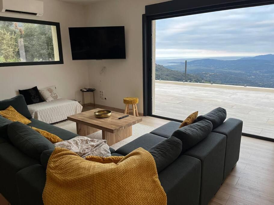 sala de estar con sofá y ventana grande en Villa à louer Corse du Sud Sollacaro 8pers, en Sollacaro