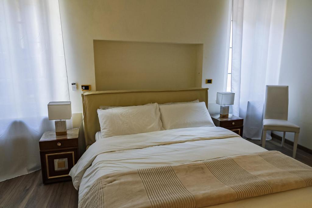 una camera da letto con un letto grande con due tavoli e due lampade di Juliet Deluxe Apartment a Verona